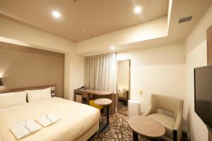 东京相铁Fresa Inn银座七丁目酒店的酒店客房配有一张床、一张桌子和一把椅子。