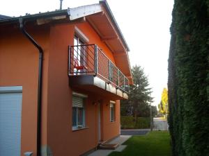 比克Apartman Molnár的一座橙色的建筑,旁边设有阳台