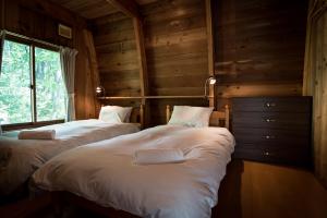 白马村Yukiita Lodge的木墙客房的两张床