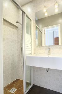 巴黎蒙庞西耶酒店的带淋浴、盥洗盆和镜子的浴室