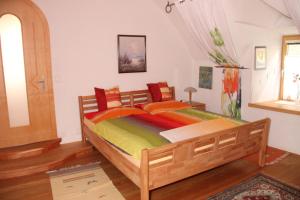 格明德Ferienwohnung Vorstadt的一间卧室配有一张大木床和色彩缤纷的床单