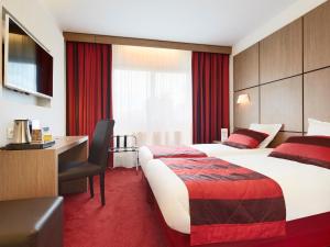 格勒诺布尔格勒诺布尔中心基里亚德酒店的酒店客房设有一张大床和一张书桌。