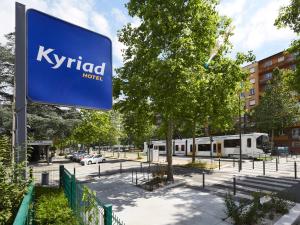 格勒诺布尔格勒诺布尔中心基里亚德酒店的一条有火车的街道旁的Kyrid标志
