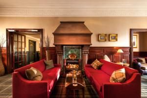 珀斯Leonardo Boutique Huntingtower Perth的客厅设有2张红色的沙发和壁炉