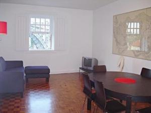 波尔图Porto Riverside的客厅配有桌椅和电视。