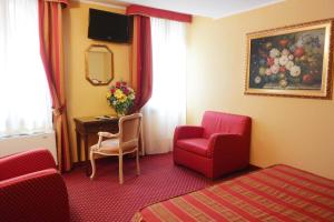 威尼斯米兰希塔迪酒店的酒店客房配有红色椅子和书桌