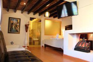 巴耶德布拉沃拉卡皮拉精品酒店的卧室配有一张床,墙上配有电视。
