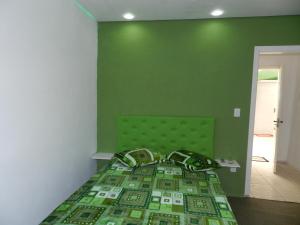 卡内拉Magias da Serra的绿色卧室,配有一张带绿色墙壁的床