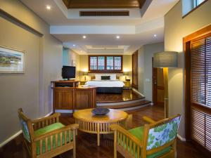 绿岛绿岛度假酒店的卧室配有一张床和一张桌子及椅子