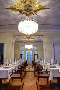 开姆尼茨拉本斯泰因城堡酒店的一间配备有白色桌椅和吊灯的餐厅