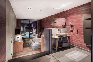 滨湖采尔Senses Violett Suites - Adults Only的一间带木墙和水槽的浴室