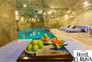 尚勒乌尔法Elruha Hotel的一个带水果和蔬菜托盘的游泳池