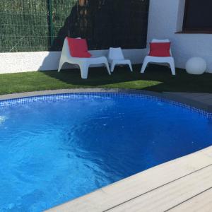 利乌玛Casa Azul的两张红色和白色的椅子和一个游泳池