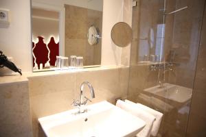 纽伦堡德尔瑞本酒店的一间带水槽、镜子和淋浴的浴室