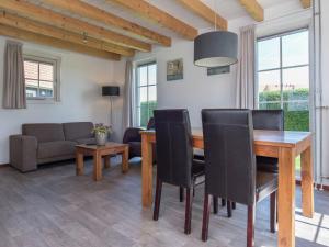 韦默尔丁厄Comfortable cottage with WiFi at 50 m from the Oosterschelde的一间带木桌和椅子的用餐室