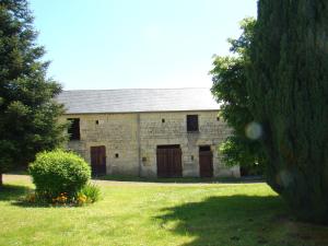 LernéHoliday home near the forest in Lern的一座古老的石头建筑,在田野上设有棕色的门