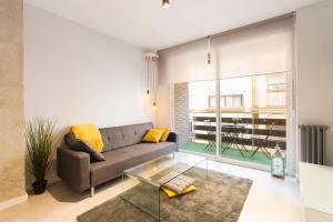 格拉纳达格拉纳达市中心公寓的带沙发和玻璃桌的客厅