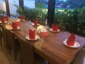 日惹罗瑟诺别墅的一张长木桌,上面有红色的餐巾和眼镜