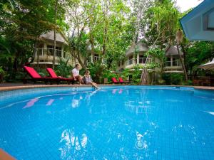 绿岛绿岛度假酒店的坐在游泳池旁的男人和孩子