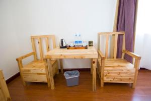 建水县涵书香院艺术客栈的一张带两把椅子的木桌和一张带电话的桌子