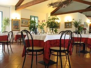 黎都-迪沃拉诺坎尼维耶餐厅酒店的餐厅配有桌椅和鲜花