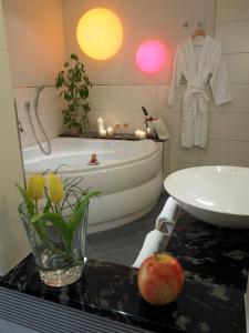 盖斯巴赫穆尔格巴赫兰德酒店的带浴缸、水槽和台面苹果的浴室