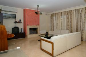 阿特米达Athenian Spiti的客厅配有白色沙发和壁炉