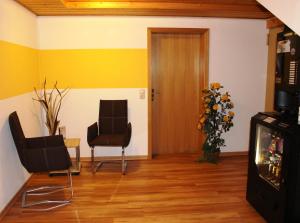 Wiesent罗切之屋旅馆的客厅配有两把椅子和一扇门