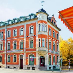 魏玛包豪斯弗斯特霍夫公寓式酒店&酒店的一座带钟楼的大型橙色砖砌建筑