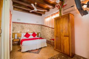 卡塔赫纳三旗酒店的一间卧室配有红色枕头的床