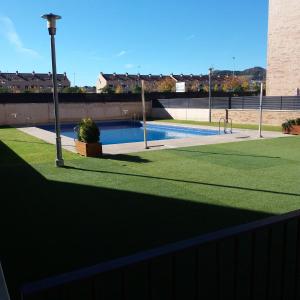LarderoPoesia y Vino的围栏旁的绿色草地游泳池