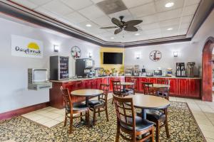 珀尔珍珠城/杰克逊机场戴斯酒店的一间带桌椅的餐厅和一间厨房