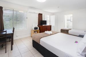 黄金海岸Sunshine Beach Resort的酒店客房配有一张床、一张书桌和一台电视。