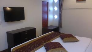 拉布安大使3号公寓&酒店的一间卧室配有一张床和一台平面电视