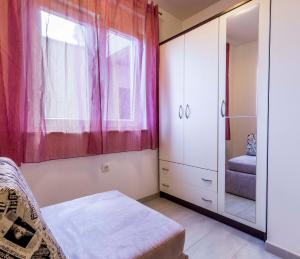 利兹扬Apartmani Lusi的一间卧室配有粉红色的窗帘和镜子