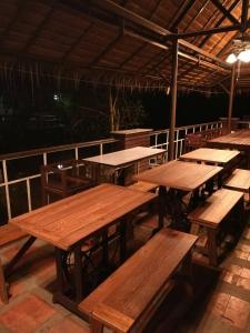 安帕瓦椰青园花园之家度假酒店的甲板上的一组木桌和长椅