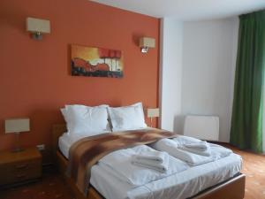 巴克乌安纳利亚出租旅馆的一间卧室配有一张带橙色墙壁的大床