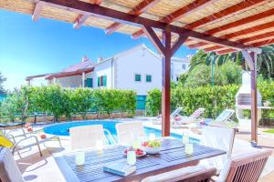 赫瓦尔Villa Cvita 80 m from the sea, free breakfast - DIRECT LANDLORD的一个带桌椅的庭院和一个游泳池