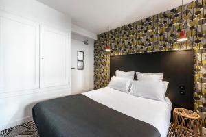 欧里亚克德斯卡默斯酒店的一间卧室配有一张大床和黑色床头板