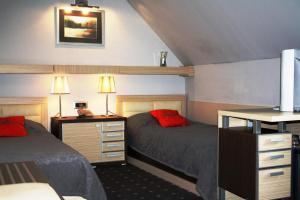 诺维萨德利奥波德一世加尼酒店的一间卧室配有两张床和一张带两盏灯的书桌。