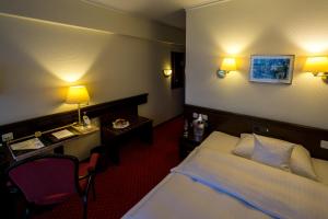 赖因贝克瑞比克萨彻森瓦尔德酒店的配有一张床和一张书桌的酒店客房