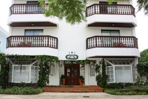 巴拉奈里奥-坎布里乌Villa Germânia的白色的房子,设有红色的门和阳台