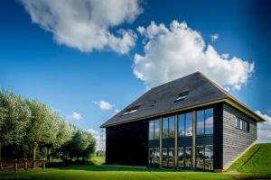 兹沃勒Buitenplaats de Luwte的绿色草坪上带窗户的黑色房子