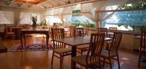 韦尔巴尼亚阿卡多斯酒店的用餐室设有桌椅和窗户。