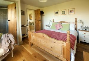 圣大卫Llety Farm的一间卧室配有一张木床,铺有木地板
