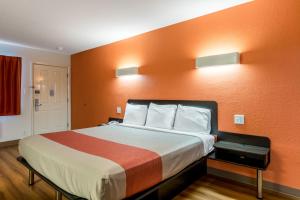 圣安东尼奥圣安东尼奥6号汽车旅馆的酒店客房,配有一张橙色墙壁的床