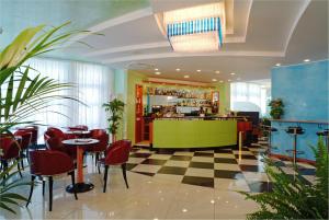 比比翁Hotel Concordia 3S的餐厅设有酒吧,配有红色椅子和 ⁇ 格地板