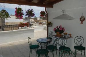 马萨夫拉Casa Camilla的一个带桌椅的庭院和一个阳台