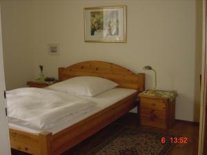 塞尔布施密特酒店的一间卧室配有一张木床、床头柜和一张四柱床