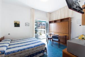 迪亚诺马里纳Casavacanze Internazionale的配有一张床和一张书桌的酒店客房